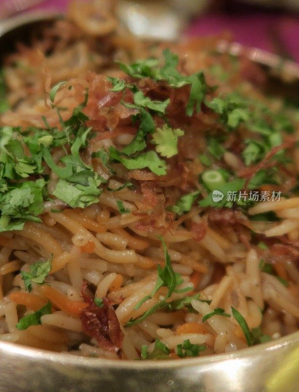 印度餐厅晚餐上的lucknowi鸡印度香饭食谱的图片，有金色的菜肴和塔利，shorba sherva肉汁酱，印度辣，鸡印度香饭香菜配菜，印度新德里的餐桌上的金属盘子